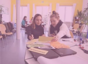 Zwei junge Teilnehmende eines Workshops des Kipppunkt Kollektivs bearbeiten selbstständig Aufgaben zu Fragen der Klimagerechtigkeit